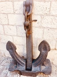 Close-up of rusty statue against wall