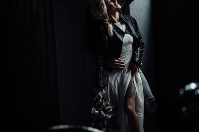 Young woman standing against black background