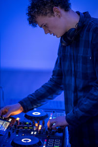 Young dj mixing music at nightclub