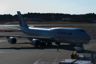 Airplane on airport runway against sky