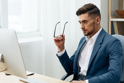 Portrait of businessman using mobile phone in office