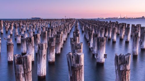 Wooden post on sea during sunset