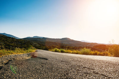 Road by mountains against clear sky