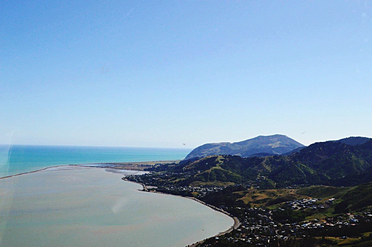 clear sky, copy space, water, sea, blue, scenics, tranquil scene, tranquility, beauty in nature, nature, mountain, horizon over water, idyllic, beach, outdoors, day, coastline, high angle view, non-urban scene, shore