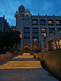 Illuminated building against sky at dusk