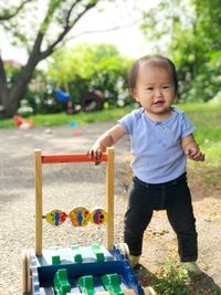 Portrait of cute girl standing by toy in playground
