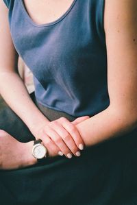 Midsection of woman sitting indoors