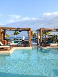 Turquoise blue water and clear skies at the tropical resort beach club cabanas. 