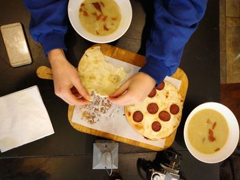 High angle view of woman holding food on table