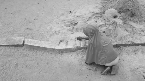 Rear view of child on sand at beach