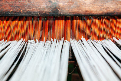 Woven threads background . tapestry loom with wooden base . ancient loom with white threads