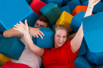 High angle portrait of couple lying amidst cubes