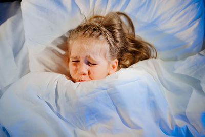 Boy sleeping on bed at home