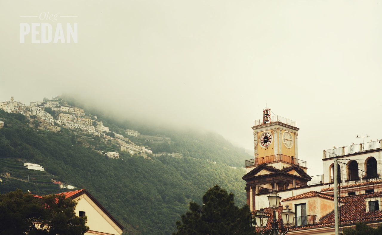 CLOCK TOWER BY TREES AGAINST SKY