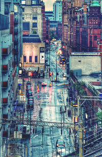 High angle view of wet street and buildings in city