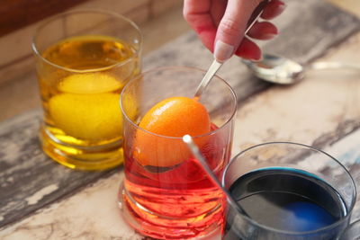 Cropped hand making easter egg on table