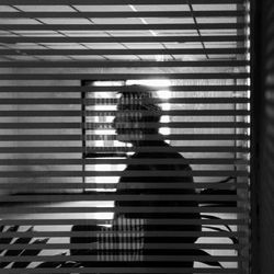 Silhouette man seen through glass in office