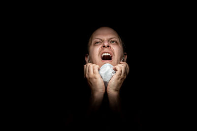 Portrait of man against black background