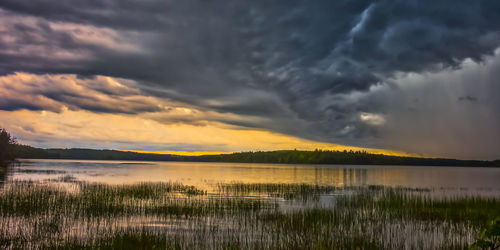 Scenic view of lake against dramatic sky