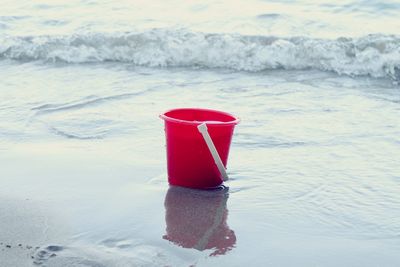 Red bucket at sea shore