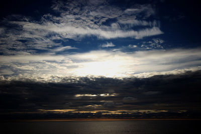 Scenic view of sea against dramatic sky during sunset
