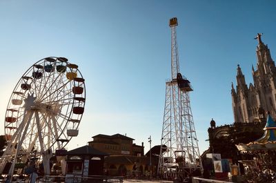 Low angle view of ferris wheel against buildings