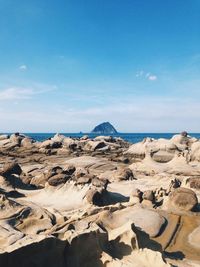 Scenic view of beach against cloudy sky