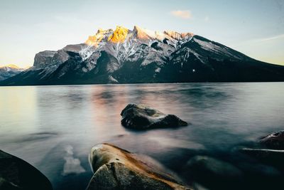 Scenic view of snowcapped mountains by sea against sky