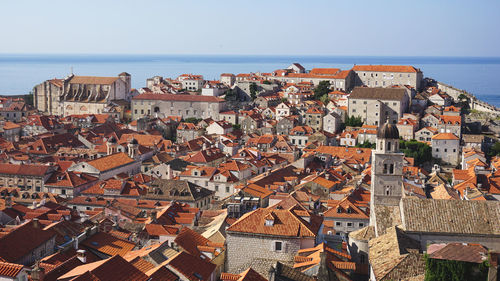 High angle view of townscape by sea against sky