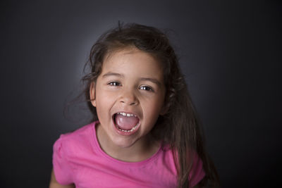 Portrait of smiling girl against gray background