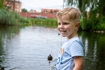 Small boy playing on a pond