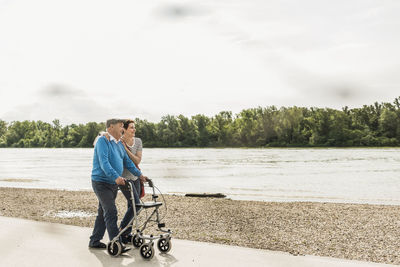 Senior man strolling with his daughter at riverside