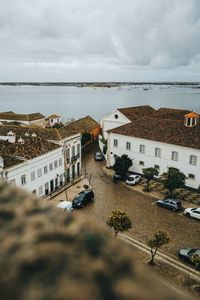 High angle view of buildings by sea against sky