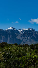 Scenic view of snowcapped mountains against blue sky