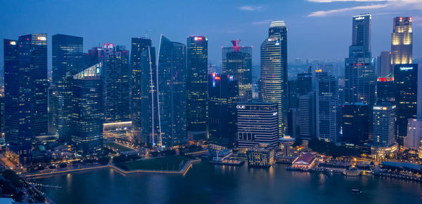 Aerial view of illuminated buildings in city against sky