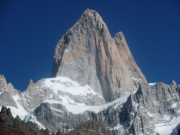 Panoramic view of snowcapped mountains against clear blue sky