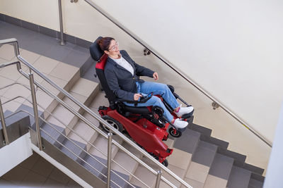 High angle view of woman sitting on wheelchair on steps