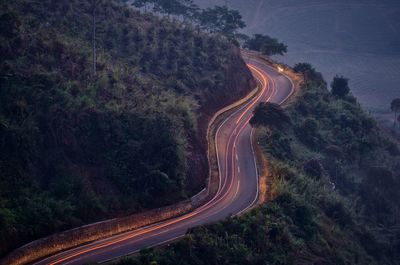 High angle view of light trails on mountain road during sunset
