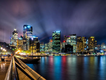 The city - sydney - illuminated buildings by bay against sky at night