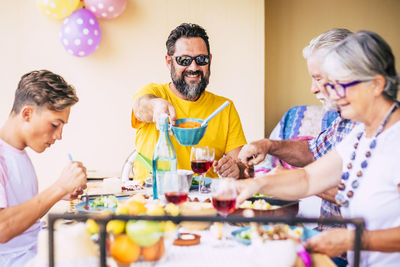 Cheerful family having food on table