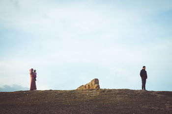 MAN STANDING ON ROCK LOOKING AT VIEW