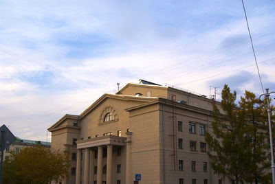 Low angle view of building against cloudy sky