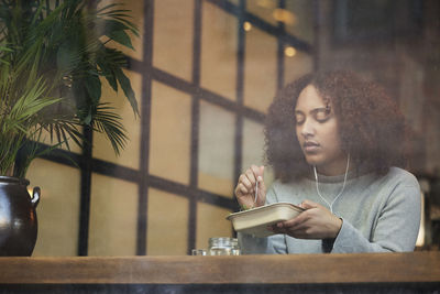 Young woman eating in cafe