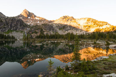 Scenic view of lake by mountains against sky