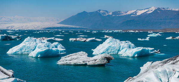 Scenic view of sea and mountains against sky
