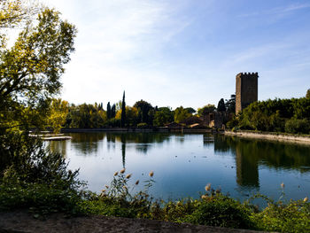 Scenic view of river by trees against sky