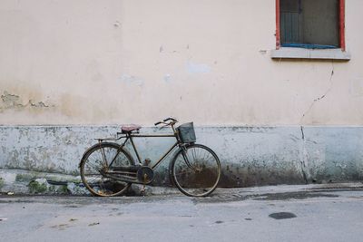 Bicycle parked against wall in city