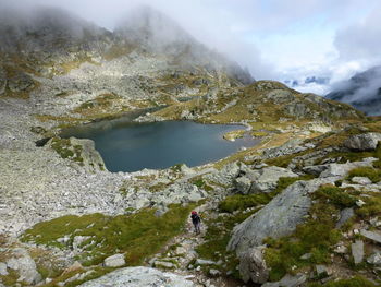 High angle view of man standing on mountain against sky