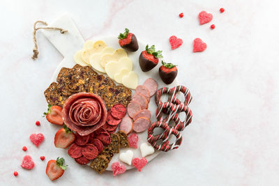 A round valentine's day charcuterie board, against a light background.