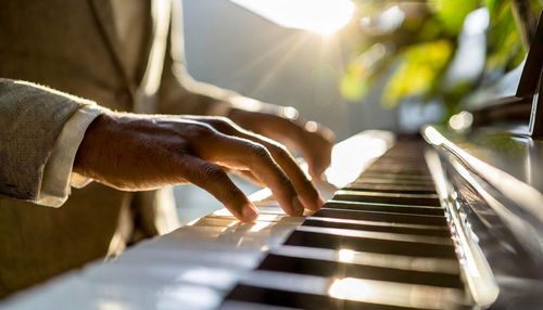 Midsection of man playing piano